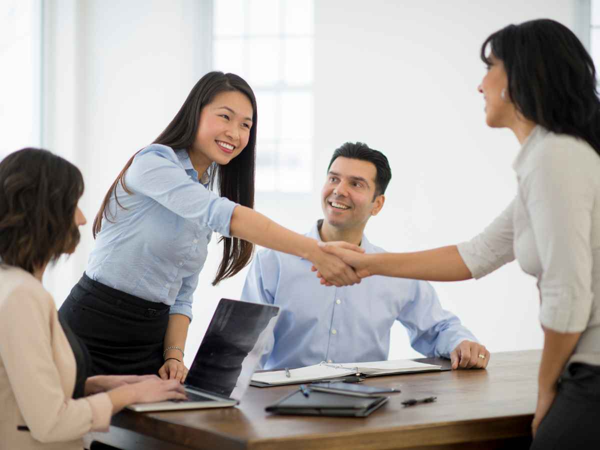 Referral partners shaking hands over a merchant cash advance affiliate program agreement